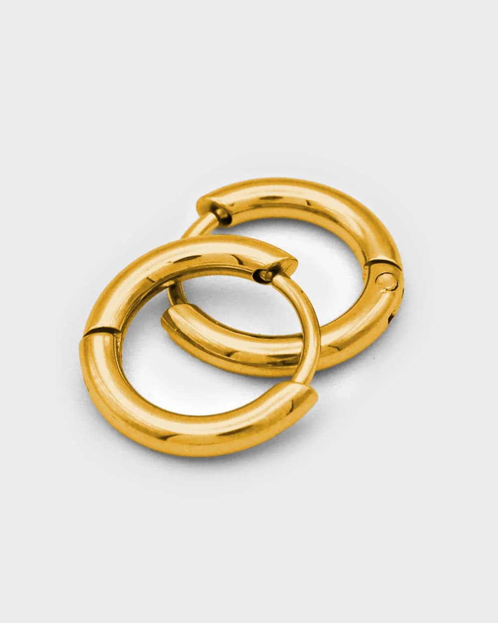 Pair of gold hoop earrings on a light gray background