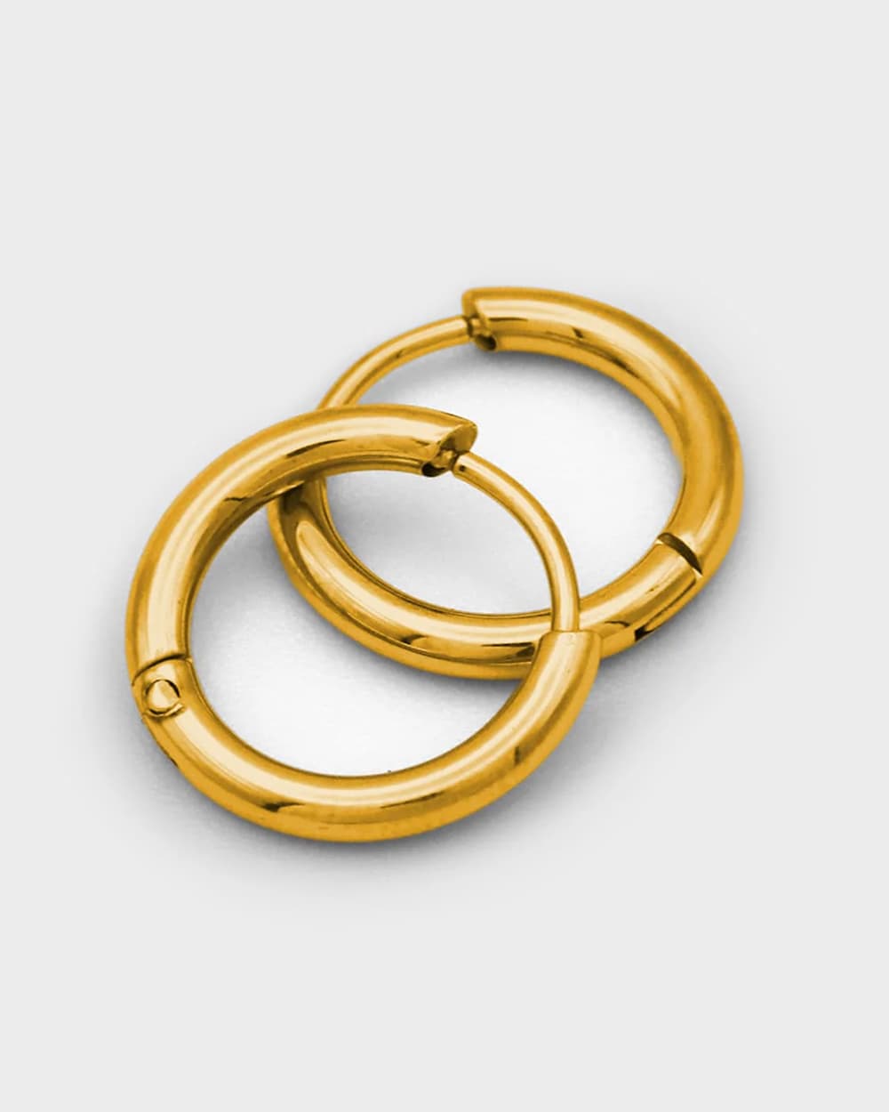 Pair of gold hoop earrings on a light gray background